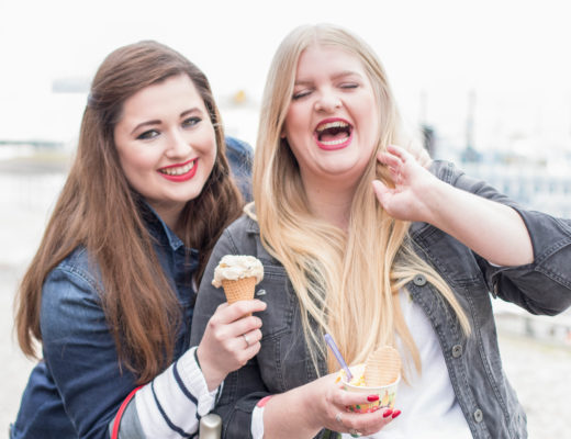 Zwei kurvige Mädchen, Eis essend und lachend in Hamburg